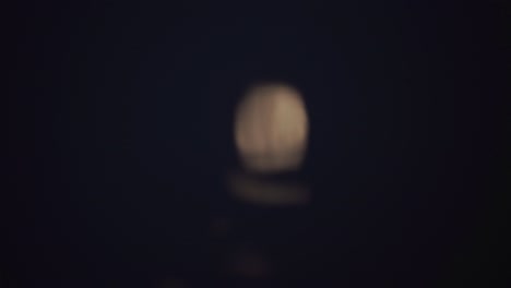 Defokussierter-Heller-Mond,-Der-Nachts-Auf-Plätscherndem-Seewasser-Reflektiert