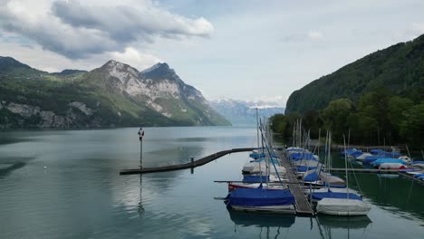 Boats-on-the-lake-in-front-of-a-small-village-in-Gäsi-Betlis,-Walensee-Glarus,-Weesen-Walenstadt,-Switzerland
