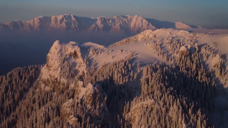Winterliches-Drohnenspektakel:-Erleben-Sie-Die-Atemberaubende-Schönheit-Eines-Schneebedeckten-Berggipfels-Bei-Sonnenuntergang,-Aufgenommen-Aus-Der-Luftperspektive