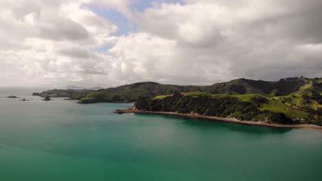 Aerial-landscape-view-of-Coromandel-Peninsula-green-and-hilly-coastline,-New-Zealand,-on-a-cloudy-day