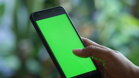 Smartphone-with-green-screen-copy-space-and-touching-fingers