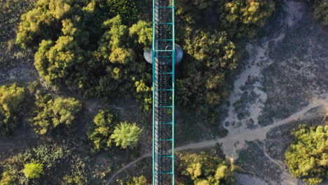 Abandoned-green-railway-bridge-in-rural-countryside-of-Spain,-aerial-top-down