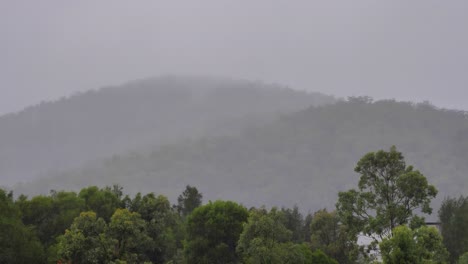Handheld-shot-of-surround-hills-of-Hinze-Dam-under-heavy-rain-during-La-Niña,-Gold-Coast-Hinterland,-Queensland,-Australia
