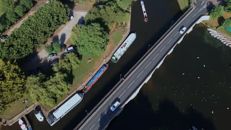 Aerial-view-rotating-over-vehicles-driving-on-Clapton-historical-archway-canal-bridge,-England
