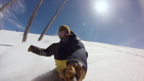 Fast-Male-Snowboarder-GoPro-selfie-backcountry-powder-slow-motion-cinematic-mid-winter-fresh-snow-blue-skies-Colorado-at-Vail-Pass-early-morning