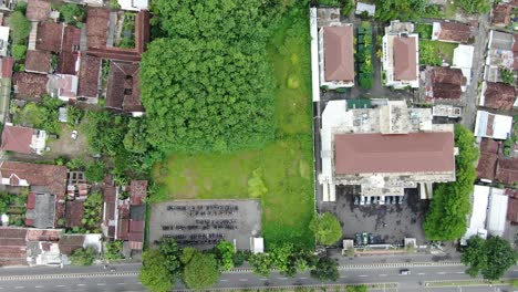 Wohngebäudedächer-Und-Grüne-Reisfelder-Am-Stadtrand-Von-Yogyakarta,-Luftaufnahme-Von-Oben-Nach-Unten