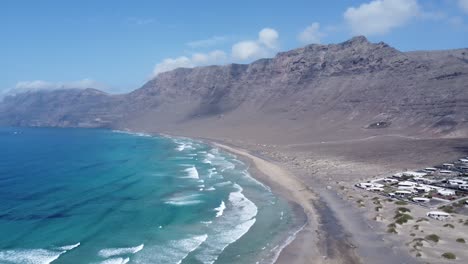 Increíble-Playa-Soleada-Con-Olas,-Famara-En-El-Norte-De-Lanzarote,-Cielo-Azul-Perfecto