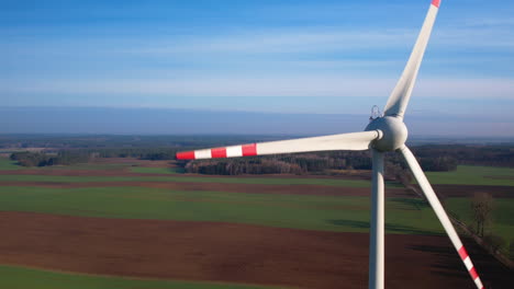 Aerial-view-close-up-of-a-wind-turbine-that-generates-electricity-on-sunny-day