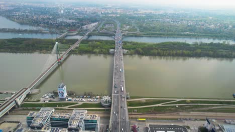 Aerial-revealing-shot-of-multiple-motorway-bridges-with-light-traffic-crossing-the-Danube-River
