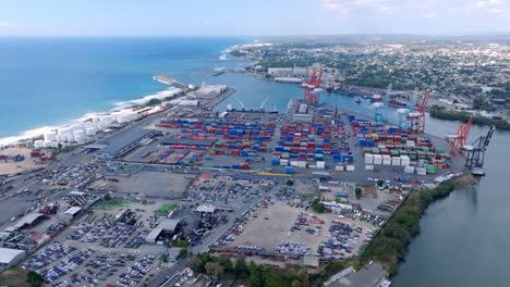 Ship-port-with-colourful-freight-containers-and-huge-cargo-cranes,-aerial-orbit