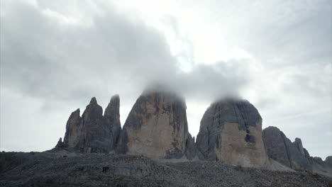 Slow-Aerial-Ascending-Shot-To-Reveal-Tre-Cime-Di-Lavaredo-With-Clouds-Over-The-Peak