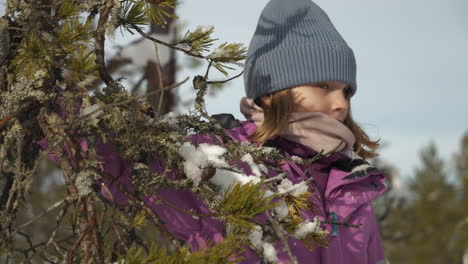 Zeitlupe-Eines-Kaukasischen-Mädchens-In-Winterkleidung-Am-Baum-Mit-Schnee