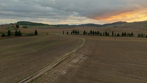 Aerial-at-sunset-over-the-Tuscany-landscape-near-Pienza,-Province-of-Siena,-Italy