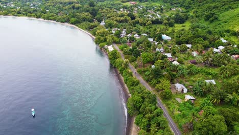 Aerial-drone-of-motorbikes-riding-along-beautiful-coastline-of-tropical-island-landscape-in-Alor-Island,-East-Nusa-Tenggara,-Indonesia