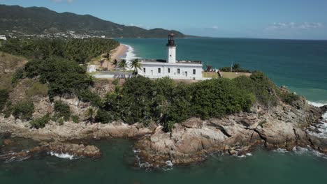 Luftaufnahmen-Des-Leuchtturms-Von-Puerto-Rico,-Drohnenaufnahmen,-Tropischer-Leuchtturm-An-Der-Küste-Der-Halbinsel,-Der-Schiffe-Vor-Steinen-Warnt