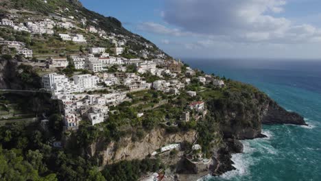 Aerial-pullback-reveals-incredible-seaside-homes-on-green-cliff,-amalfi-coast-italy