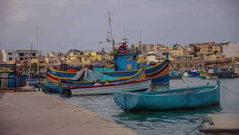 Boats-at-the-pier-and-anchored-at-Marsaxlokk,-Malta---time-lapse