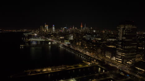 Aerial-view-of-piers-and-and-the-illuminated-Tribeca-cityscape-of-Manhattan,-NY