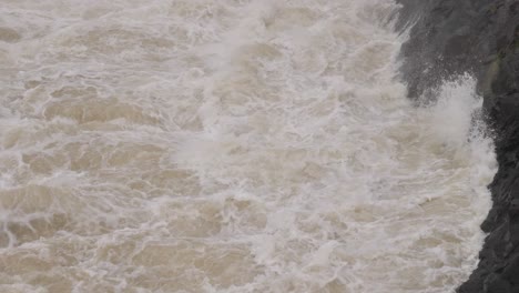 Handheld-shot-of-turbulent-waterflow-from-Hinze-Dam-under-heavy-rain-and-water-flows-during-La-Niña,-Gold-Coast-Hinterland,-Queensland,-Australia