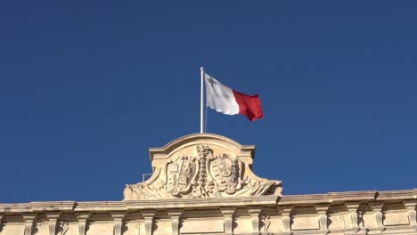 Bandera-De-Malta-Ondeando-En-La-Parte-Superior-De-La-Plaza-De-Castilla-En-La-Valleta-Con-Cielo-Azul-De-Fondo