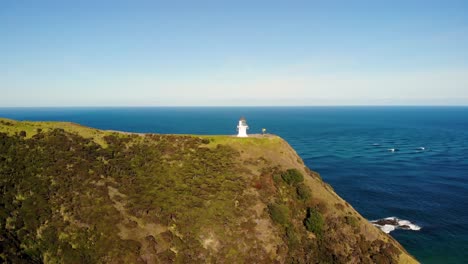 Iconic-Cape-Reinga-Lighthouse-aerial-pullback,-morning-at-New-Zealand-scenic-spot