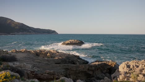 Wellen-Krachen-Auf-Einsamen-Felsen-Im-Meer-Bei-Sonnenuntergang-An-Der-Küste-Mallorcas-In-Zeitlupe