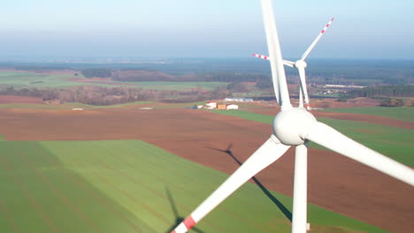 Nahaufnahme-Einer-Windmühle,-Die-Sich-Auf-Landwirtschaftlichem-Ackerland-Dreht---Drohnenaufnahme