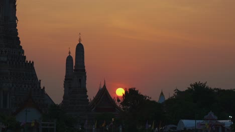Stunning-close-up-shot-of-a-sunset-behind-Wat-Arun-temple-in-Bangkok,-Thailand