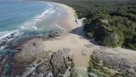 Ocean-Waves-Splashing-On-The-Beach-In-Wenonah-Head,-Urunga,-Australia---drone-shot