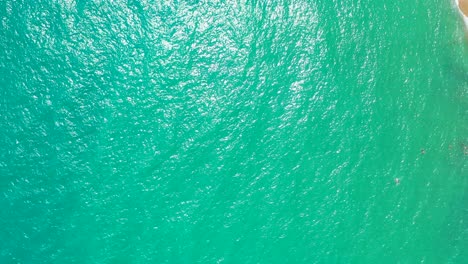 Smaragdgrünes-Meerwasser,-Auf-Dessen-Oberfläche-Sich-Die-Sonne-Spiegelt