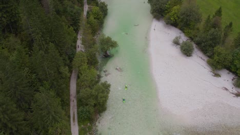 Kayak-going-down-the-emerald-alpine-river-Soca-on-a-bright-summer-day,-aerial