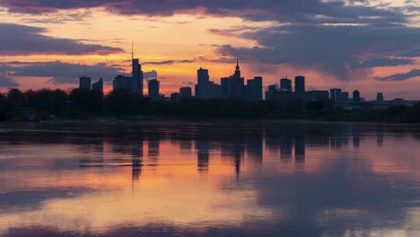 The-Warsaw-skyline-and-the-river-at-sunset,-captured-in-a-time-lapse-video-with-stunning-golden-colours