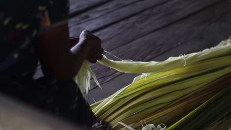 Close-up-of-indigenous-person-assembling-a-hammock-with-palm-leaves-in-slow-motion