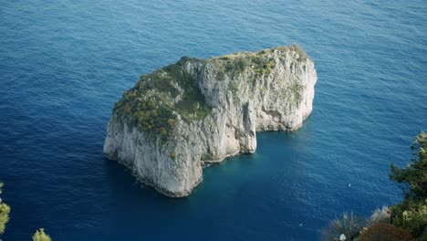 Top-down-view-of-the-smallest-of-Capri's-Faraglioni,-the-famous-cliffs-of-this-beautiful-island
