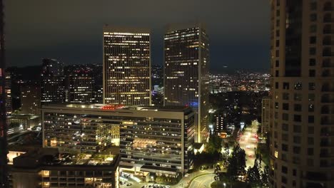 Establishing-cinematic-view-of-Century-City-between-buildings,-aerial-flyover-at-night