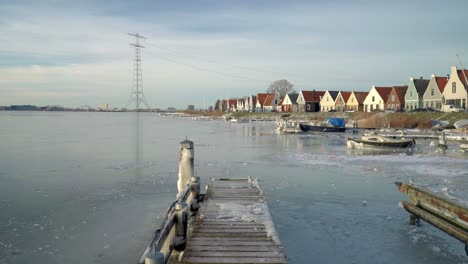 Traditional-Dutch-village-Durgerdam-in-the-rare-white-winter,-frozen-pond,-boats-and-wooden-houses-in-the-background,-Amsterdam,-Netherland