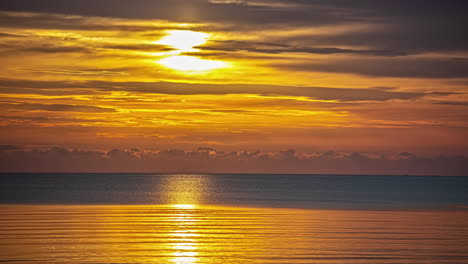 Vibrant-sunset-over-calm-ocean-water,-time-lapse-view