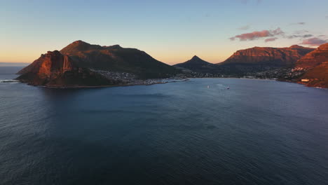 Chapman-Peak-South-Africa-sunset-drive-aerial-cinematic-drone-Hout-Bay-marina-Cape-Town-Fish-Hoek-Good-Hope-Table-Mountain-waves-crashing-rugged-coast-aqua-deep-blue-water-green-summer-to-the-left