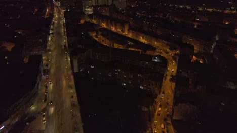 Drone-footage-flying-over-Almada-at-night,-Portugal