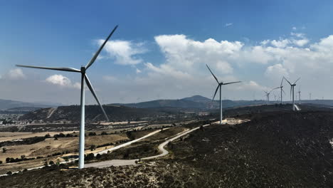 Windmills-rotating-and-generating-energy-in-Puebla,-Mexico---Static,-drone-shot
