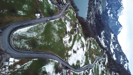 Cars-driving-down-a-serpentine-alpine-mountain-road-in-Switzerland