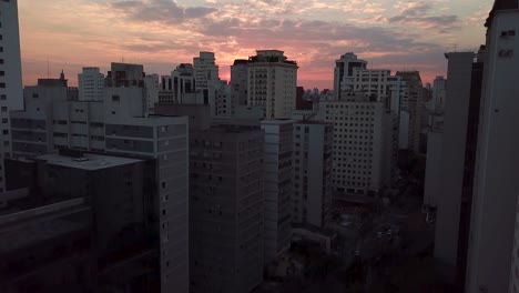 Incredible-establishing-aerial-shot-of-sunset-in-center-of-Sao-Paolo,-crazy-color-sky-and-sun
