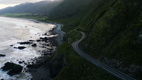 Aerial-following-the-coastline-and-road-near-Ruatapu-in-the-Western-District,-South-Island,-New-Zealand