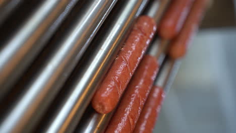 Vertical-Shot-Of-Sausages-Cooked-In-Roller-Machine