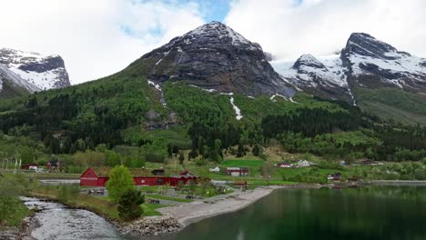 Jostedal-Glacier-National-Park-Visitor-Center-in-Stryn-Norway---Aerial-showing-location-close-to-Oppstrynsvatnet-lake-with-huge-snow-capped-mountain-peaks-on-glaciers-edge-in-background