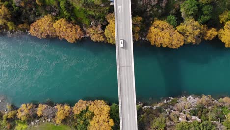 Weißer-Lieferwagen-Fährt-über-Die-Brücke,-Herbstfarben