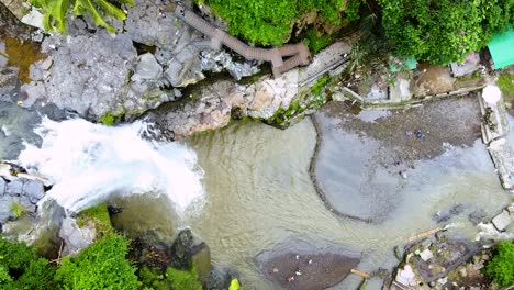 Aerial-top-down-view-of-fresh-powerful-waterfall-isolated-amidst-dense-greenery