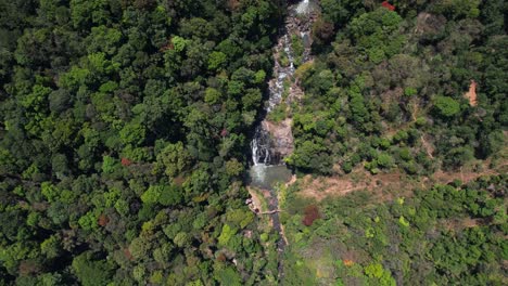 Aerial-view-of-the-waterfalls,-which-are-encircled-by-a-dense-forest