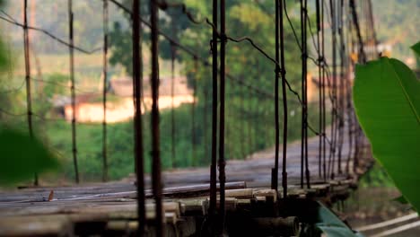 Die-Hölzerne-Hängebrücke-Schwankt,-Nachdem-Sie-Das-Fahrzeug-Passiert-Hat---Ländlicher-Blick-Auf-Die-Indonesische-Landschaft