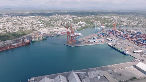Riesige-Frachtkräne-Im-Hafen-Von-Haina,-Aus-Der-Luft-Rückwärts,-Errichten-Containerstandort